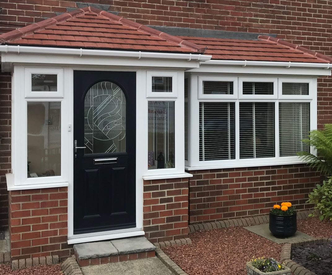 Black entrance door on a contemporary home with white uPVC windows