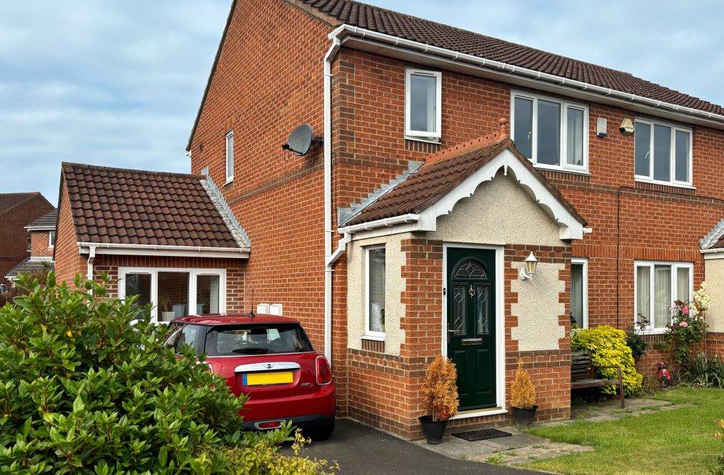 front of house with a black front door and in progress garage conversion